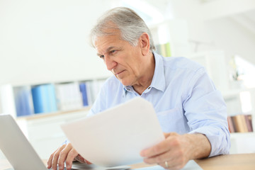 Senior man working on laptop computer