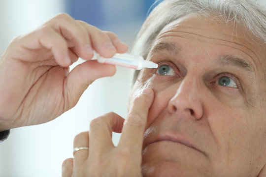 Senior man injecting eye serum