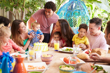 Group Of Families Celebrating Child's Birthday At Home
