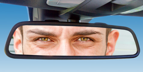 Augen im Rückspiegel eines Autos