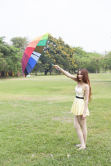 Woman with umbrella standing on the lawn.