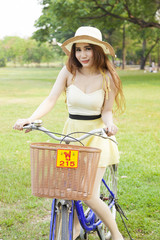 Woman riding bicycle on the lawn.