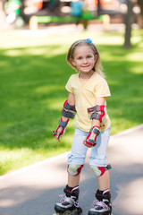 Fototapeta premium Little girl rollerskating in the park
