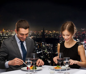 smiling couple eating main course at restaurant
