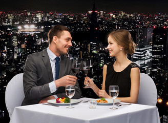 smiling couple eating main course at restaurant