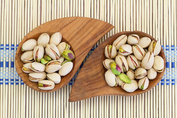 Pistachio nuts in miniature wooden bowls, close up