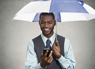 Happy executive reading news on smart phone, holding umbrella