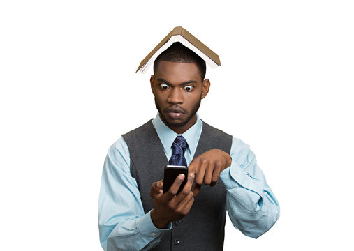 Man holding mobile, book over head, shocked, unexpected news
