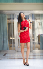 Obraz premium Beautiful woman in red dress in the shop