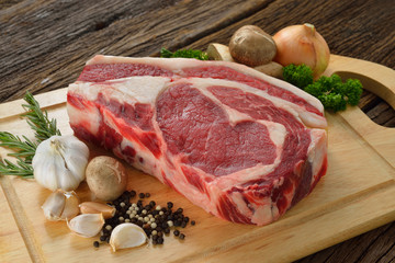 Raw meat ready to be cooked on wooden background ,rib eye steak
