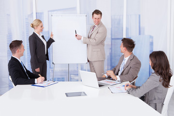 Businessman Giving Presentation To Colleagues In Office