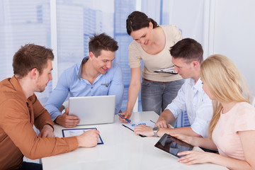 Fototapeta premium Businesswoman Discussing With Colleagues In Office