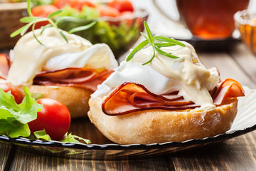 Eggs Benedict on toasted muffins with ham