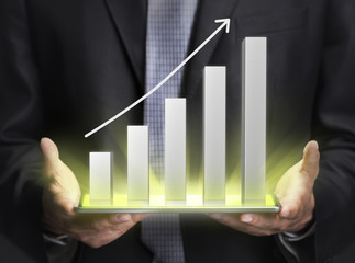 Businessman holding a graph showing growth