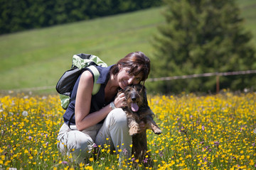 Donna e cane sul prato fiorito