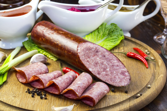 sausages on a wooden plate with vegetables in a restaurant