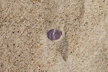 Coin in sand.