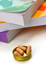 book and  capsule pills on white background