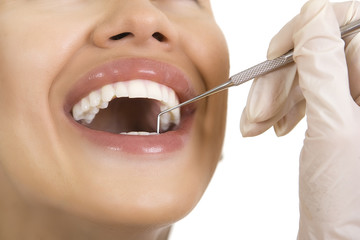 Close-up of female patient having her teeth examined by dentist