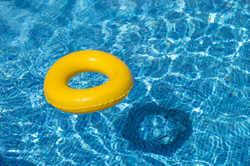 Yellow pool float, pool ring in cool blue refreshing water