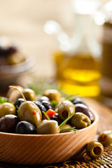 Marinated olives in wooden plate.