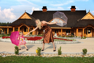 Mama z małą córeczką bawią się parasolkami.