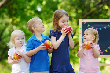 Four excited little kids by a chalkboard