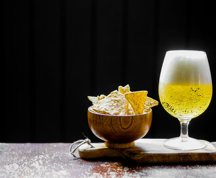 Beer and chips on wooden background