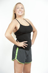A Young sporty female blond happy on a white background in a studio.