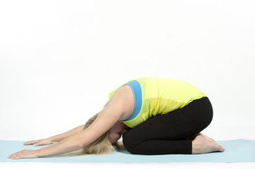 Young female model showing the child's pose in yoga - also known as Balasana.