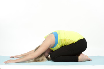 Young female model showing the child's pose in yoga - also known as Balasana.