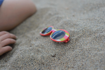 Striped sunglasses in the sand