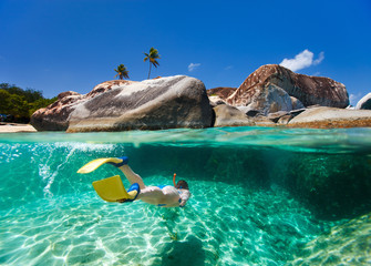 Woman snorkeling in tropical water - obrazy, fototapety, plakaty