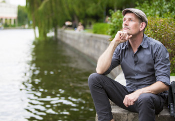man sitting by the water