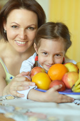 Fototapeta na wymiar Mother and daughter eating fruits