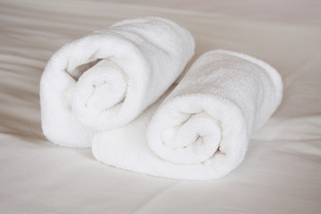 Fototapeta na wymiar white rolled towels on white cloth