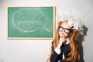 Schoolgirl at the blackboard in the classroom