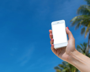 Woman hand showing a blank smart phone on the beach