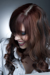 A young happy female model headshot in a studio.