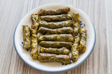 Stuffed Grape Leaves in White Plate on Wooden Background
