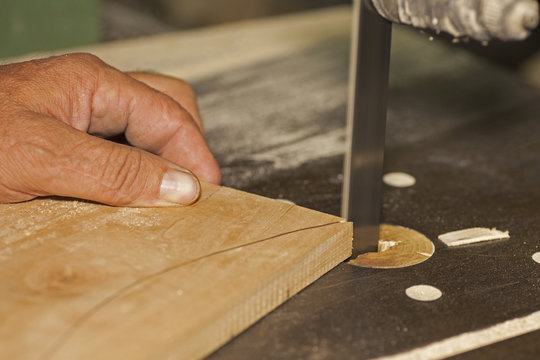 Carpenter Sawing On Bandsaw