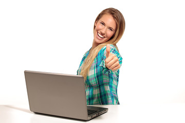 Happy  woman using laptop seated at the desk