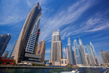 Fototapeta na wymiar Dubai Marina with boat against skyscrapers in Dubai, UAE