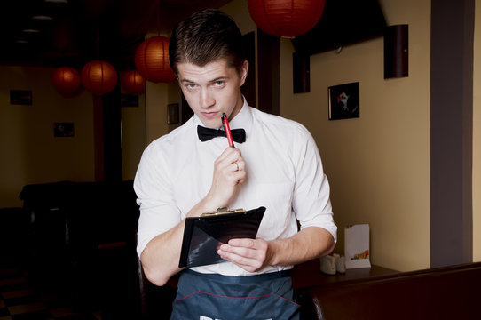 Handsome bartender in uniform with menu.