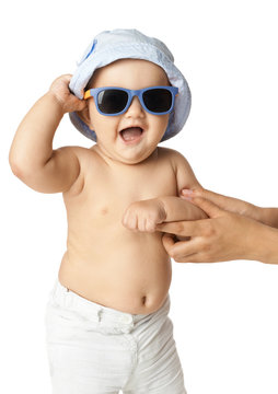 baby in panama and sunglasses laughing