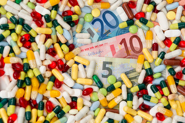 various pills and capsules with money