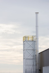 Factory chimney in the white sky