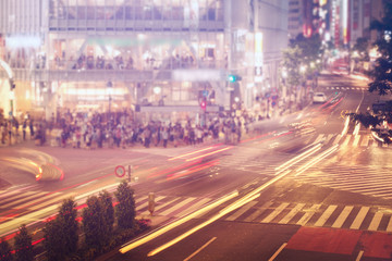 Cars and people crossing a busy Tokyo intersection
