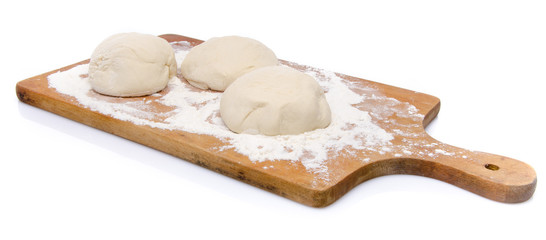 Three balls of pizza dough on a wooden board