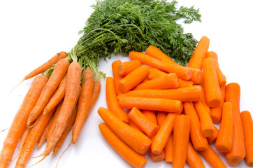 Bunch of fresh carrots and heap of peeled carrots